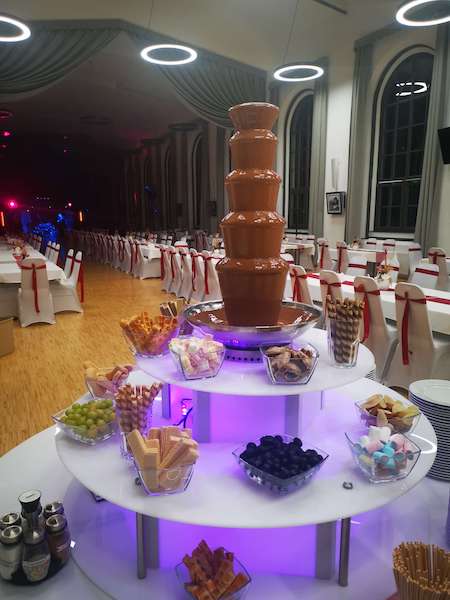 Csokoládészökőkút dekoratív, világító asztalon mártogatnivalókkal